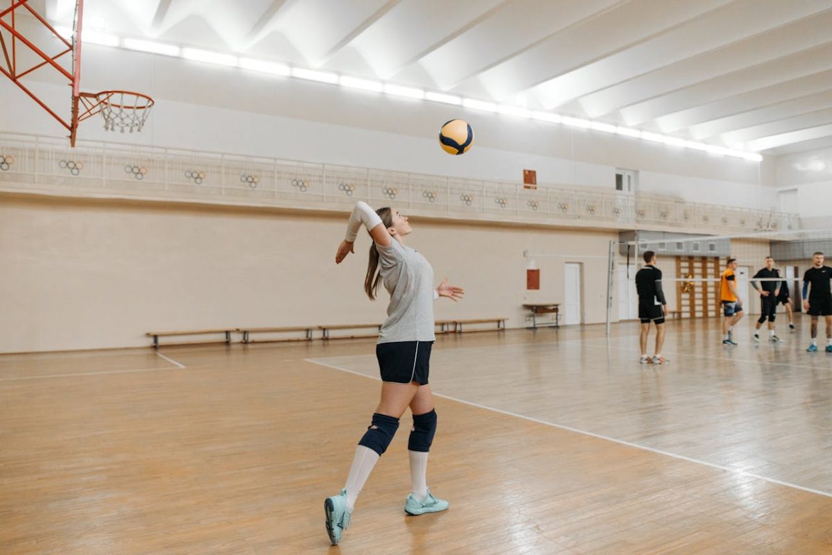 Sportlerin beim Aufschlag während eines Volleyballtrainings in der Halle