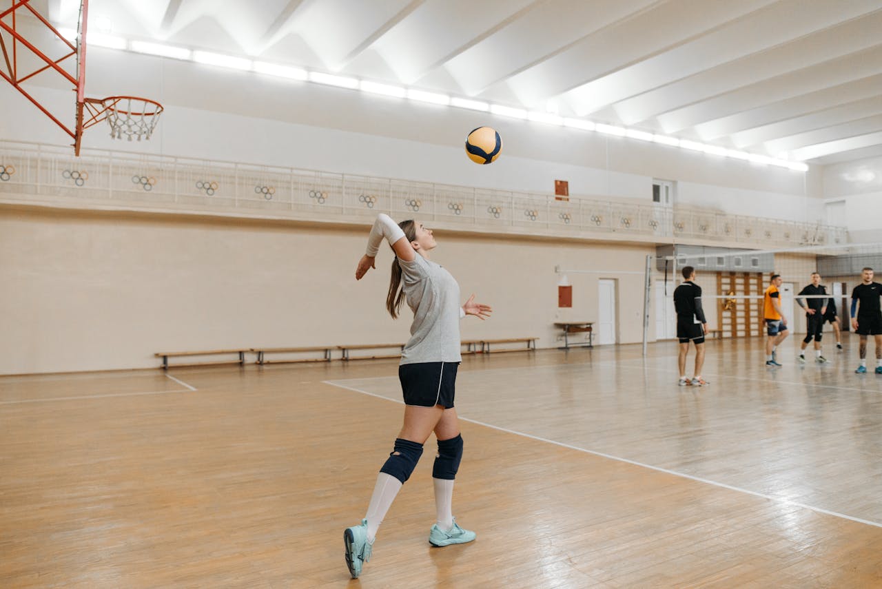 Sportlerin beim Aufschlag während eines Volleyballtrainings in der Halle